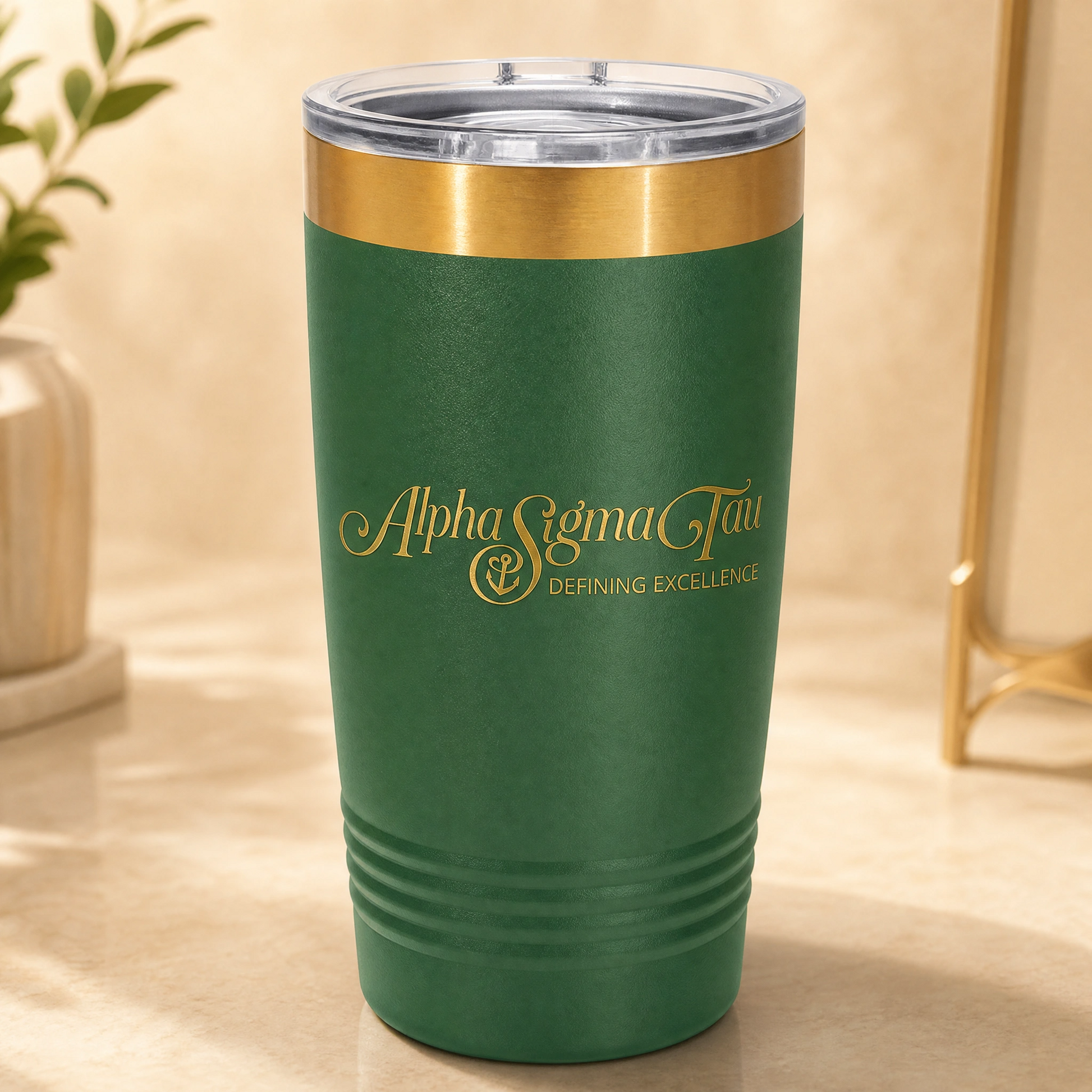 Green tumbler with gold rim and 'Alpha Sigma Tau' logo on a beige surface.